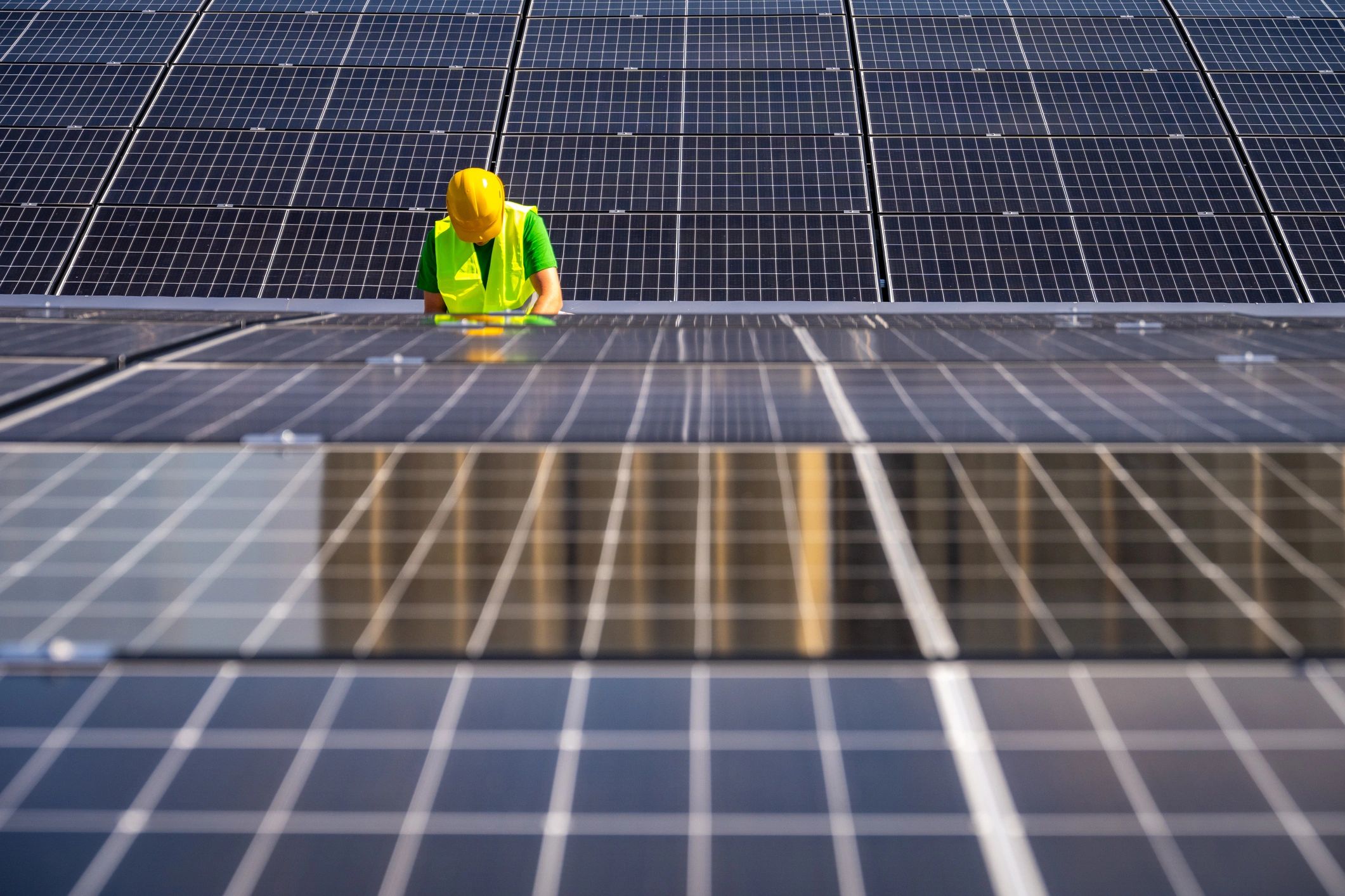 Technician inspecting solar panels as part of a renewable energy system